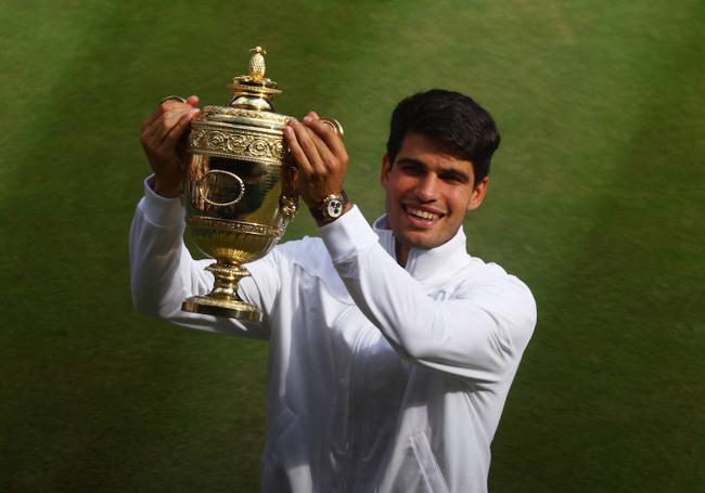 Carlos Alcaraz levanta ayer el trofeo de campeón de Wimbledon, ayer en el All England Club.