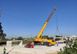 Trabajadores y maquinaria en las obras de la construcción del puente del Garruchal.