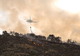 Uno de los helicópteros que participan en las labores de extinción, este jueves por la mañana.