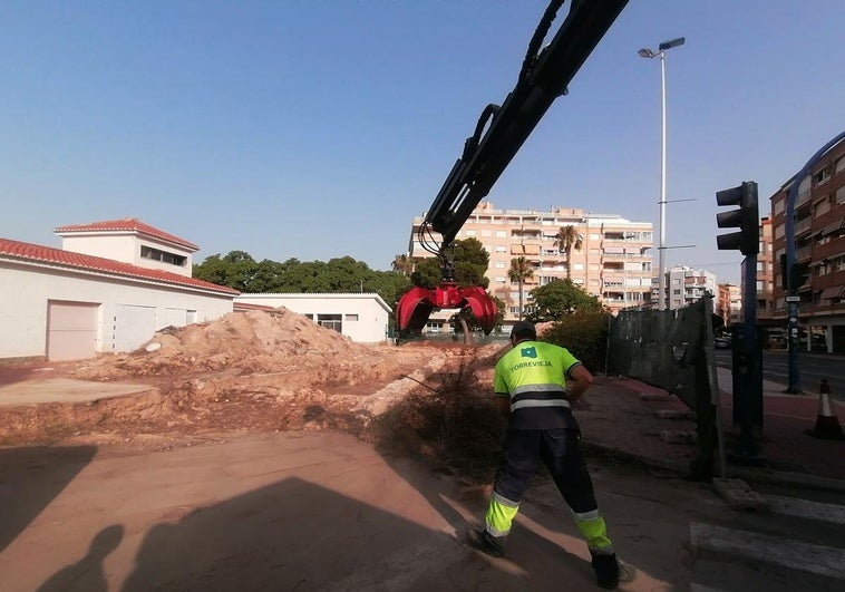 Un operario de Acciona apila los montones de poda para que los cargue el camión pulpo.