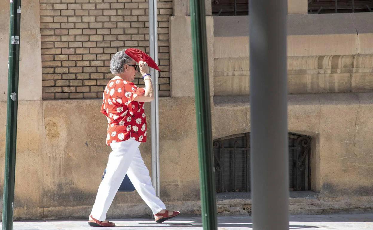 Una señora se proteje del calor con un abanico en calle Santa Clara, en una imagen de archivo.
