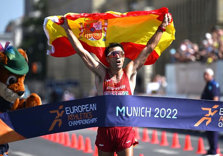 El marchador cruza la meta primero, mostrando la bandera de España, en los 35 kilómetros del Europeo de 2022.