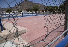 Agujero en la malla del patio del colegio de Isla Plano, por donde se cuelan al caer el sol niños y adolescentes del pueblo para practicar deporte.