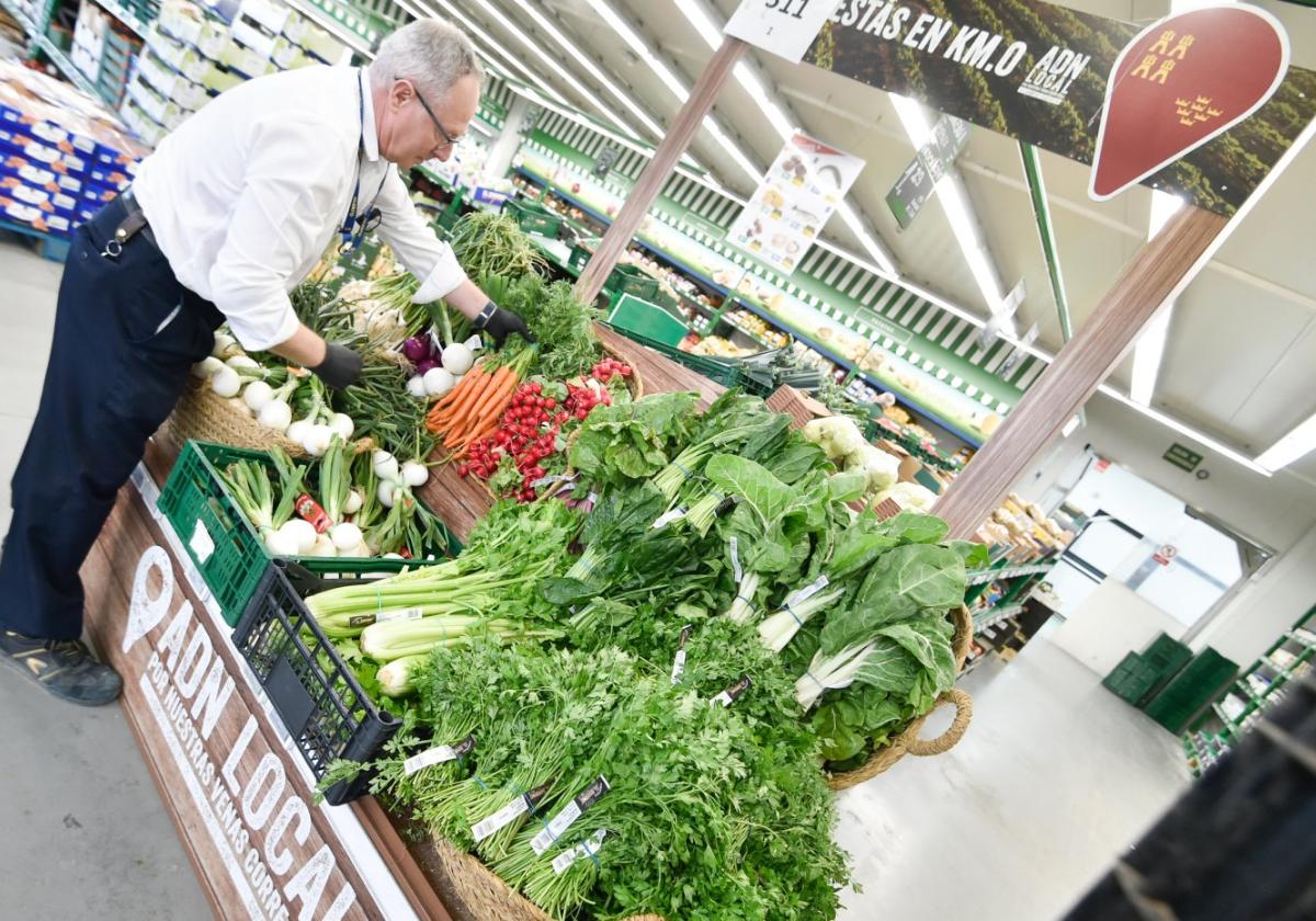 Un trabajador de Makro coloca las hortalizas de la huerta de Murcia en un expositor de la tienda ubicada en la pedanía de Patiño.