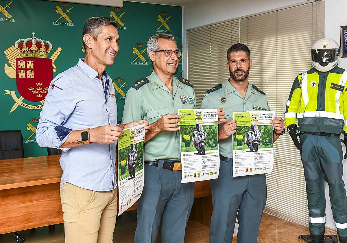 Dos agentes de la Guardia Civil posan con el cartel de la carrera solidaria.