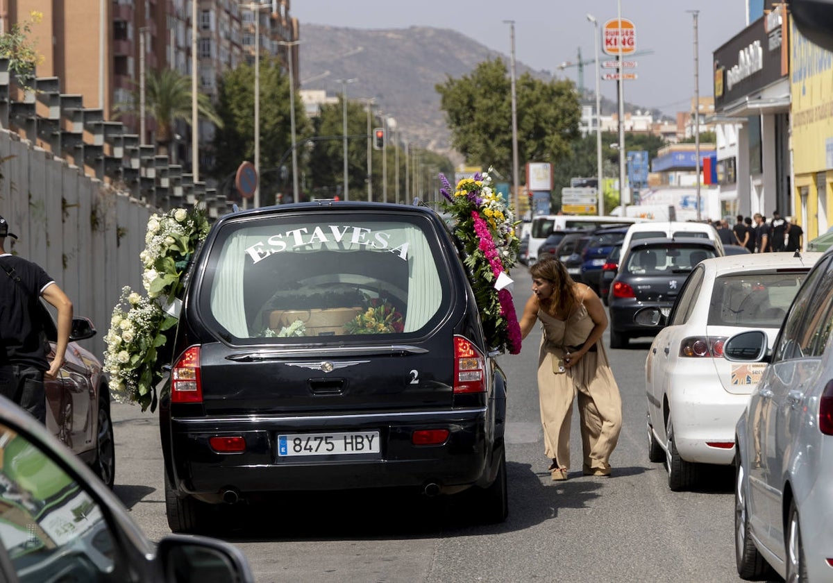 La concejal de Política Social, Cristina Mora, despide a los familiares en el coche fúnebre, mientras que a la izquierda se ve un grupo de amigos de Manu.