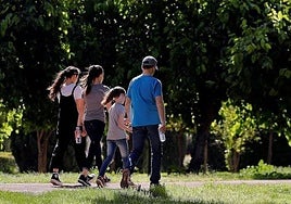 Una familia pasea por una zona verde, en una imagen de archivo.