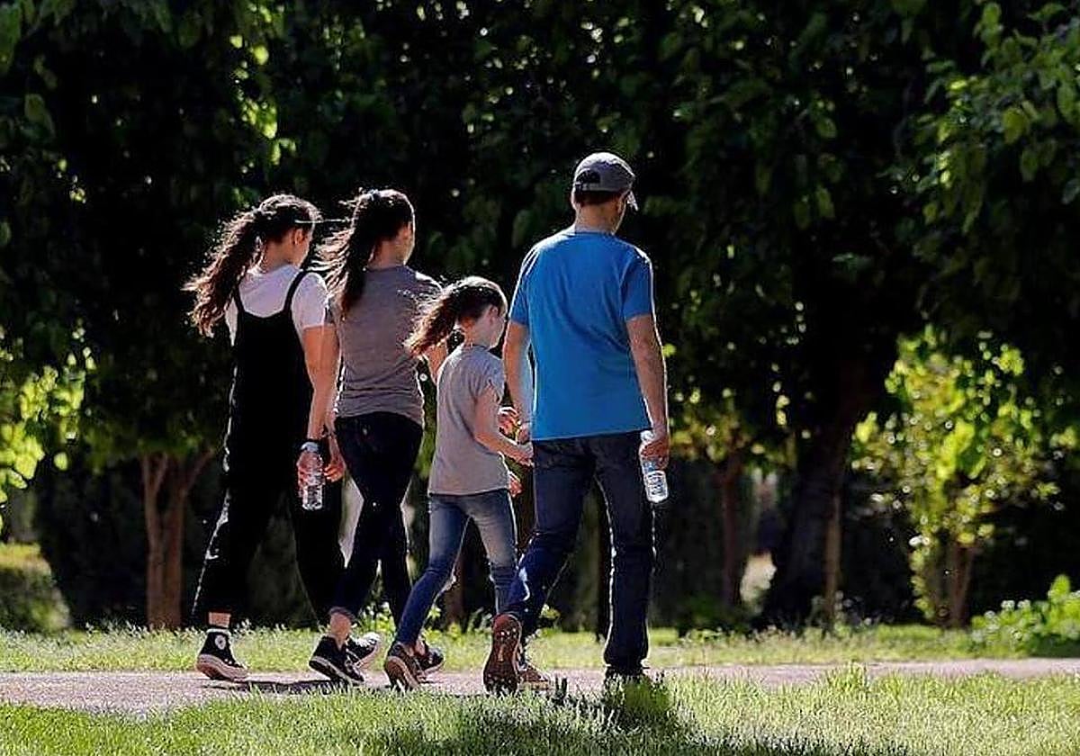 Una familia pasea por una zona verde, en una imagen de archivo.