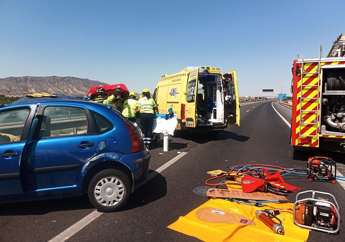 Sanitarios y bomberos atienden a una de las víctimas de los accidentes registrados este sábado en la autovía A-7.