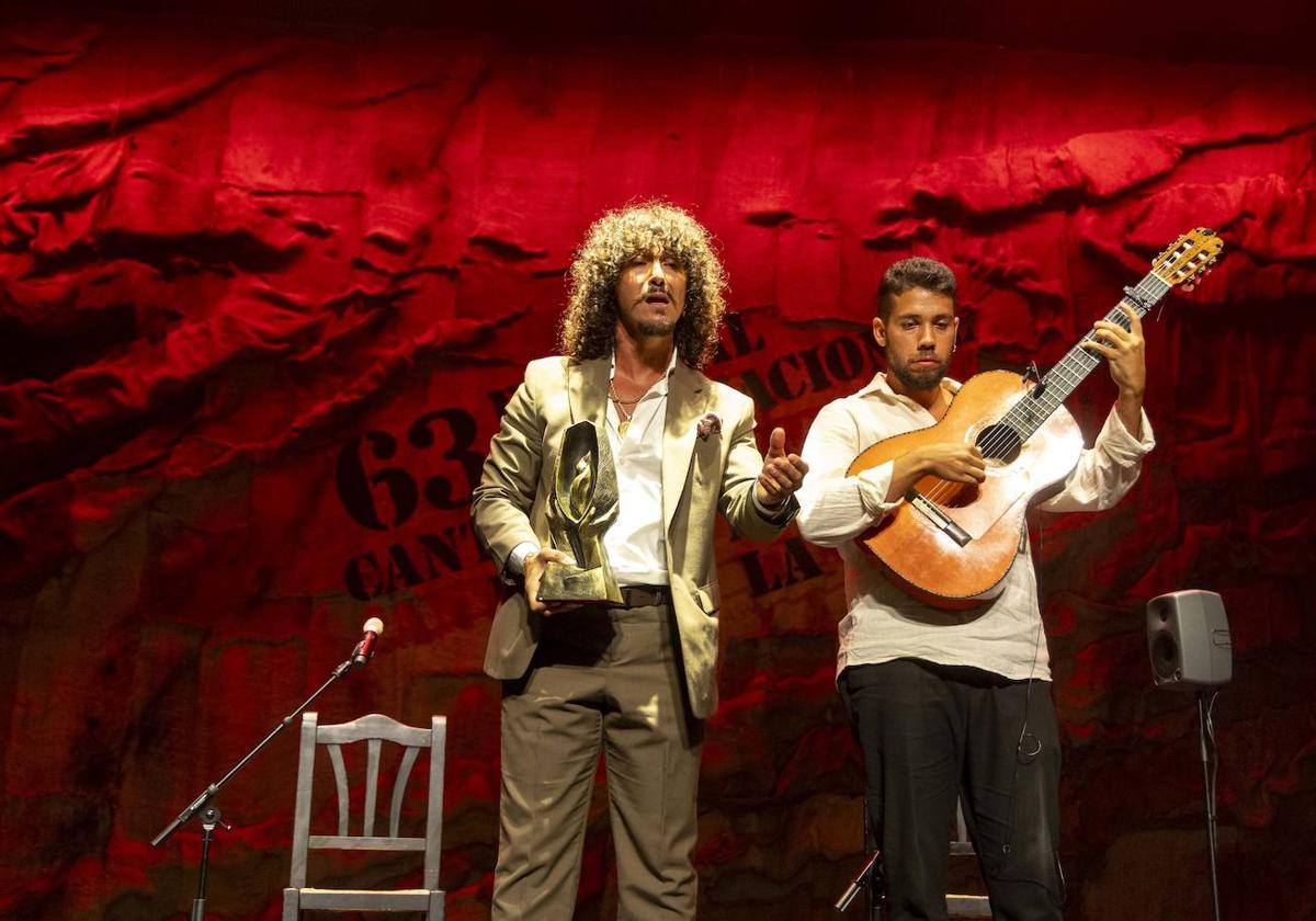 Jesús Corbacho sosteniendo la Lámpara Minera tras recibir el galardón en la madrugada de este domingo en la Catedral del Cante.