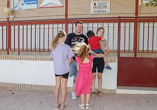 Alfonso Cánovas y Lorena Blázquez, con sus tres hijos, frene al colegio Príncipe de España de Alhama de Murcia.