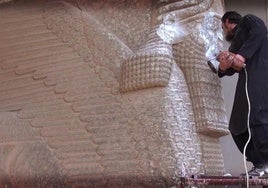 Un terrorista del ISIS destruye una obra en el Museo de Mosul (Irak).