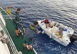 Agentes de la Guardia Civil y una embarcación.