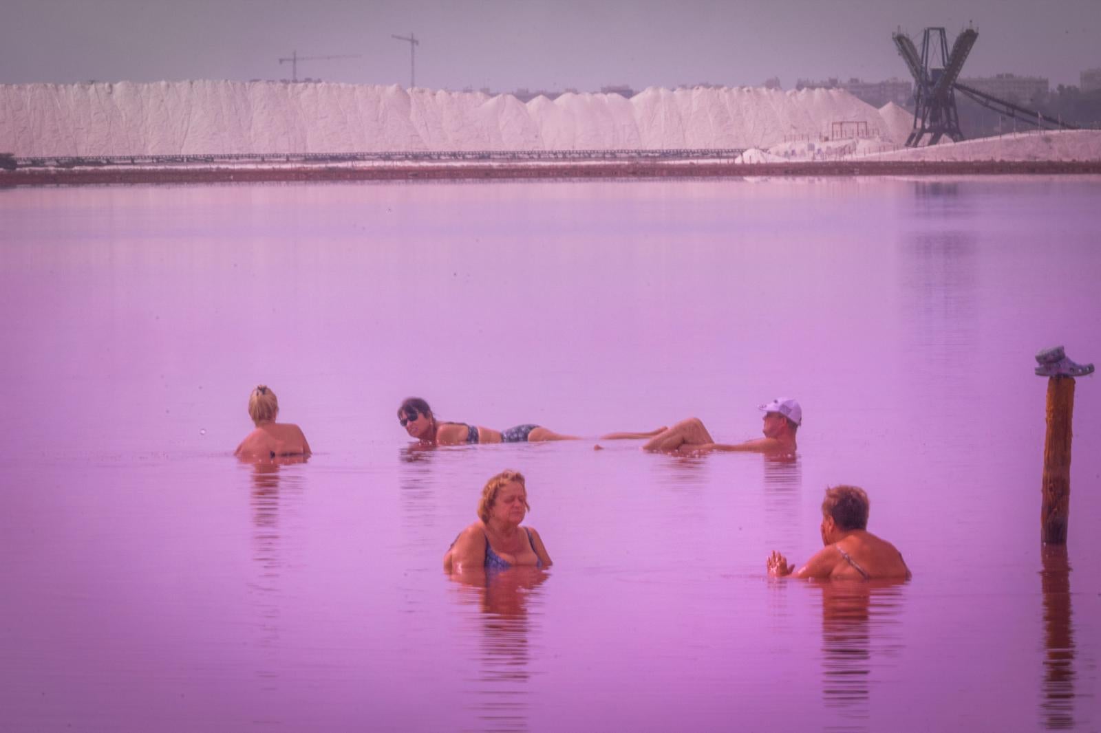 Los turistas toman las orillas de la Laguna Rosa de Torrevieja pese a la prohibición al baño