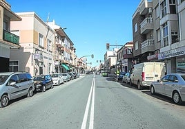 Imagen de archivo de una calle con coches aparcados.
