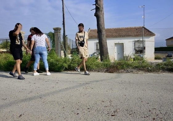 Allegados de la víctima observan los restos de sangre frente a la vivienda donde fue apuñalado.