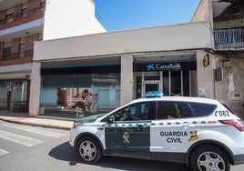 Un coche de la Guardia Civil frente al banco del atraco.