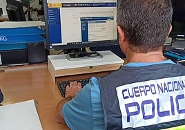 Un agente de la Policía Nacional observa documentos de la investigación.