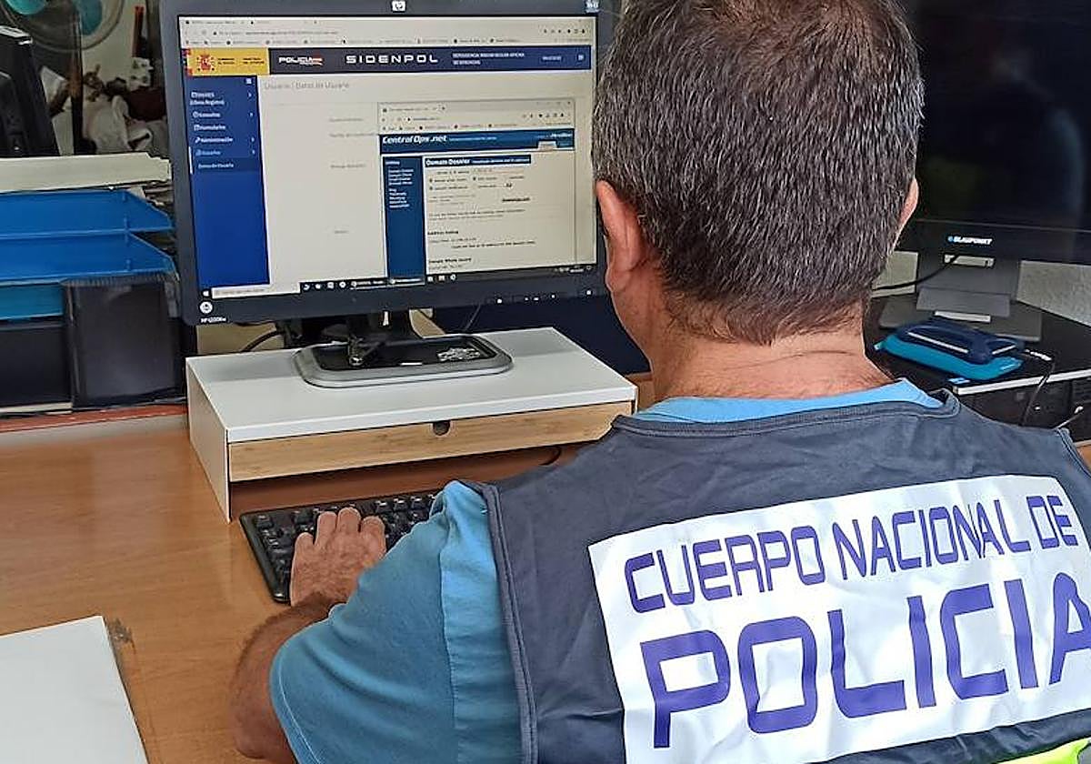 Un agente de la Policía Nacional observa documentos de la investigación.