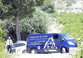 Un vehículo de la Guardia Civil y otro del servicio funerario en el lugar de un siniestro.