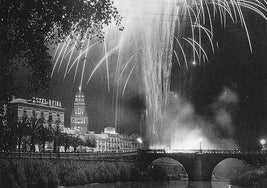 Una de las más bellas fotografías de un castillo de fuegos artificiales sobre el río Segura y, a la derecha, el histórico hotel Reina Victoria. En el centro, la torre de la catedral iluminada.