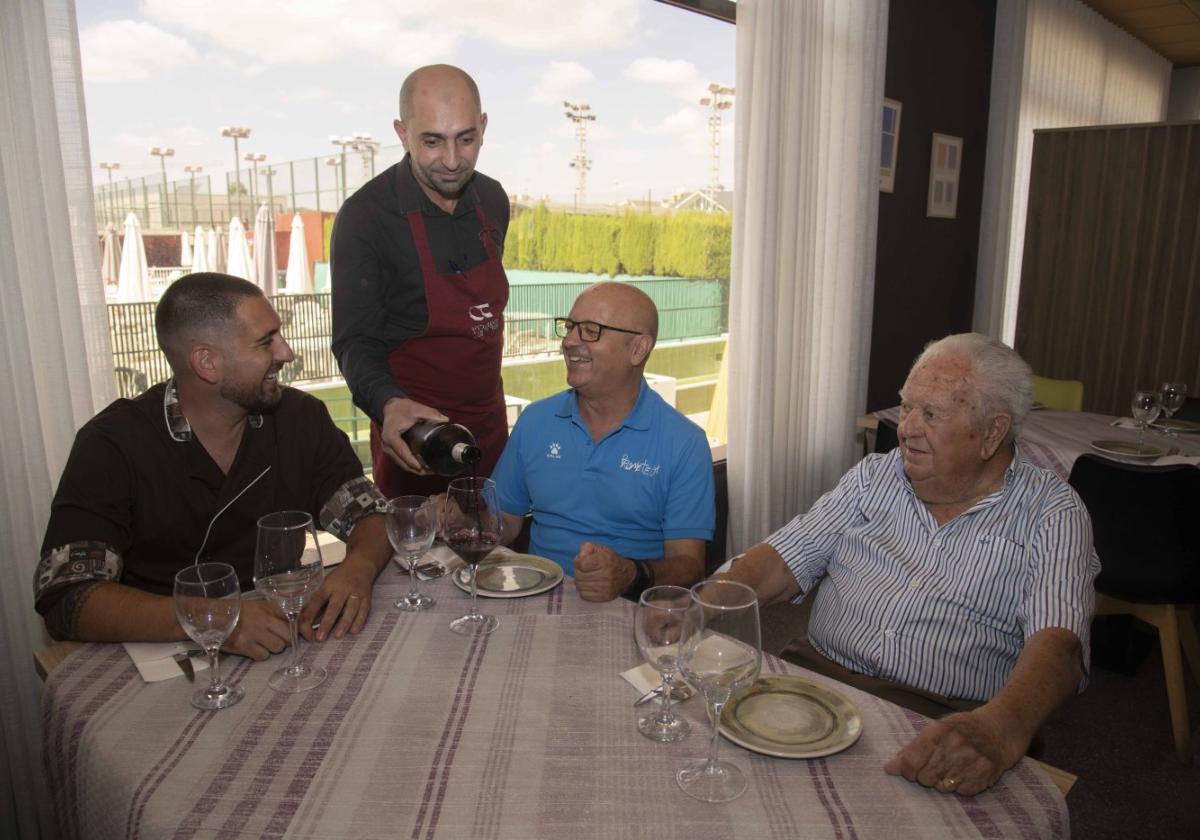 Un camarero sirve vino a Matías Pérez, gerente del restaurante club de tenis, a Luis Fernández, gerente de Prometeo, y a Pedro Giménez.