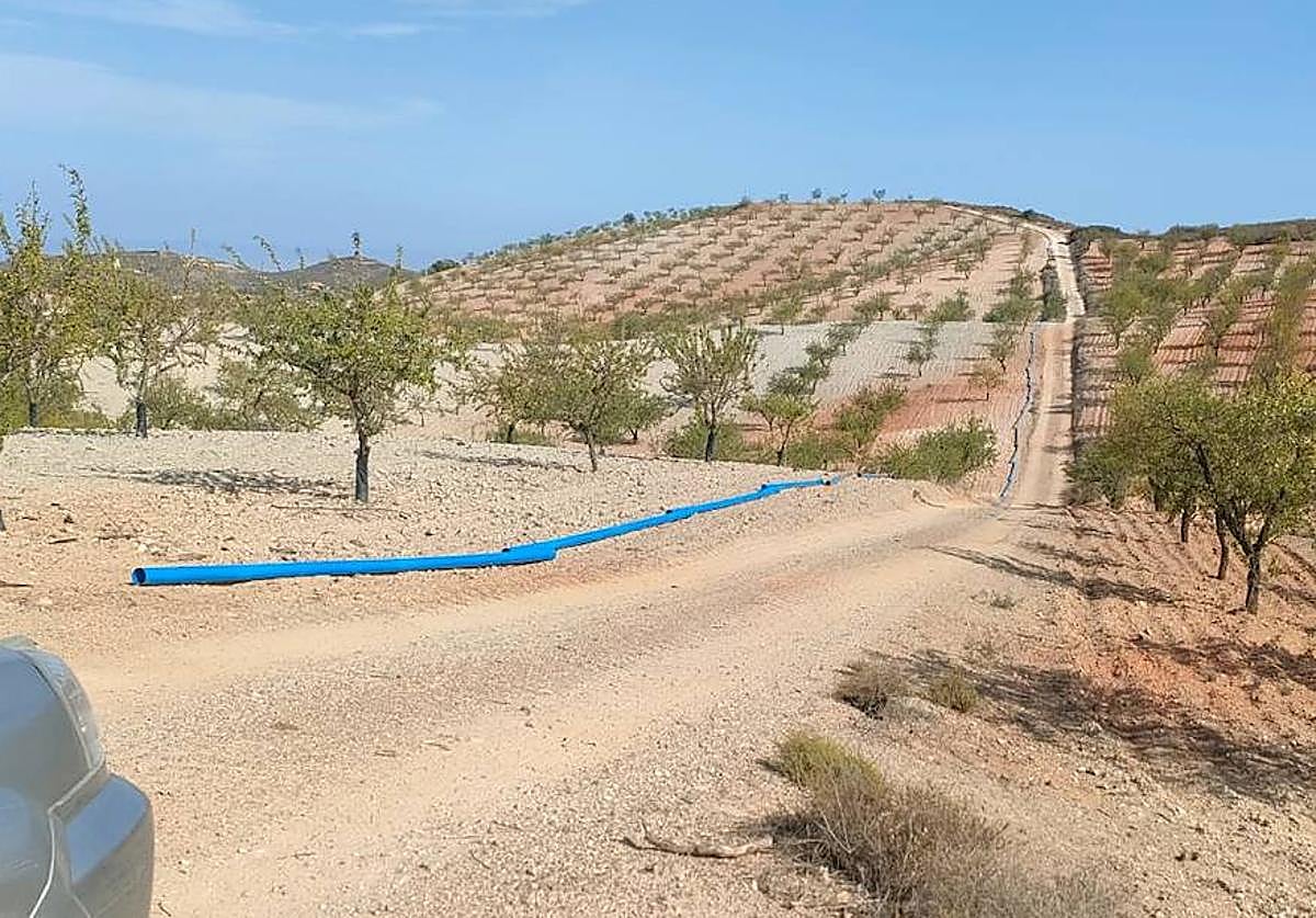 Imagen principal - Tubos preparados junto al camino para instalarlos; y enterrados (abajo). Ramal bajo la ctra. de La Parroquia.