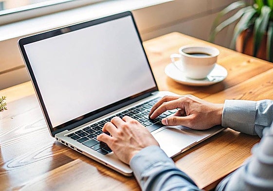Un hombre tecleando en su ordenador.