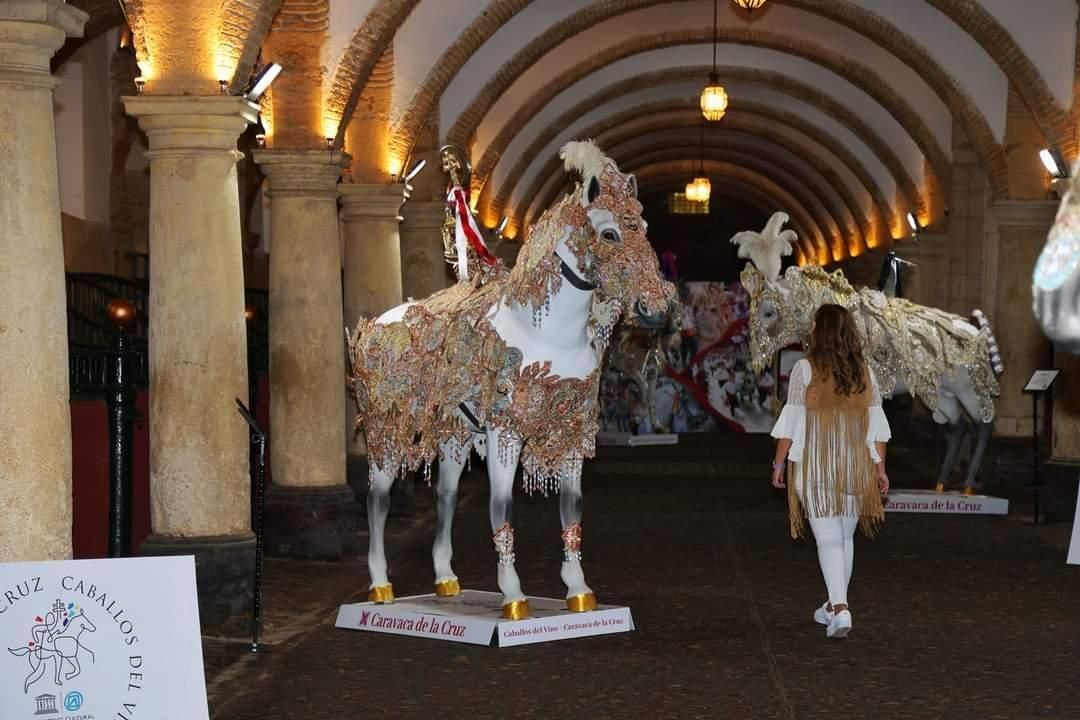 Una mujer contempla la exposición de los Caballos del Vino en la cuadra principal de las Caballerizas Reales de Córdoba.