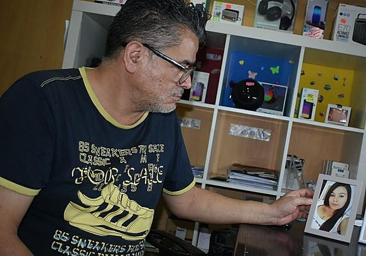 Jairo Correa, con una imagen de su hija en su tienda de móviles de Caravaca.