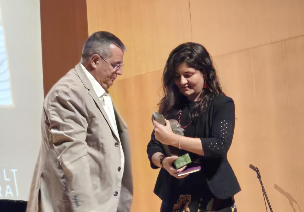 El presidente de la Fundación Miguel Hernández, Aitor Larrabide, entrega el premio de poesía a la ganadora, la autora chilena Micaela Paredes.