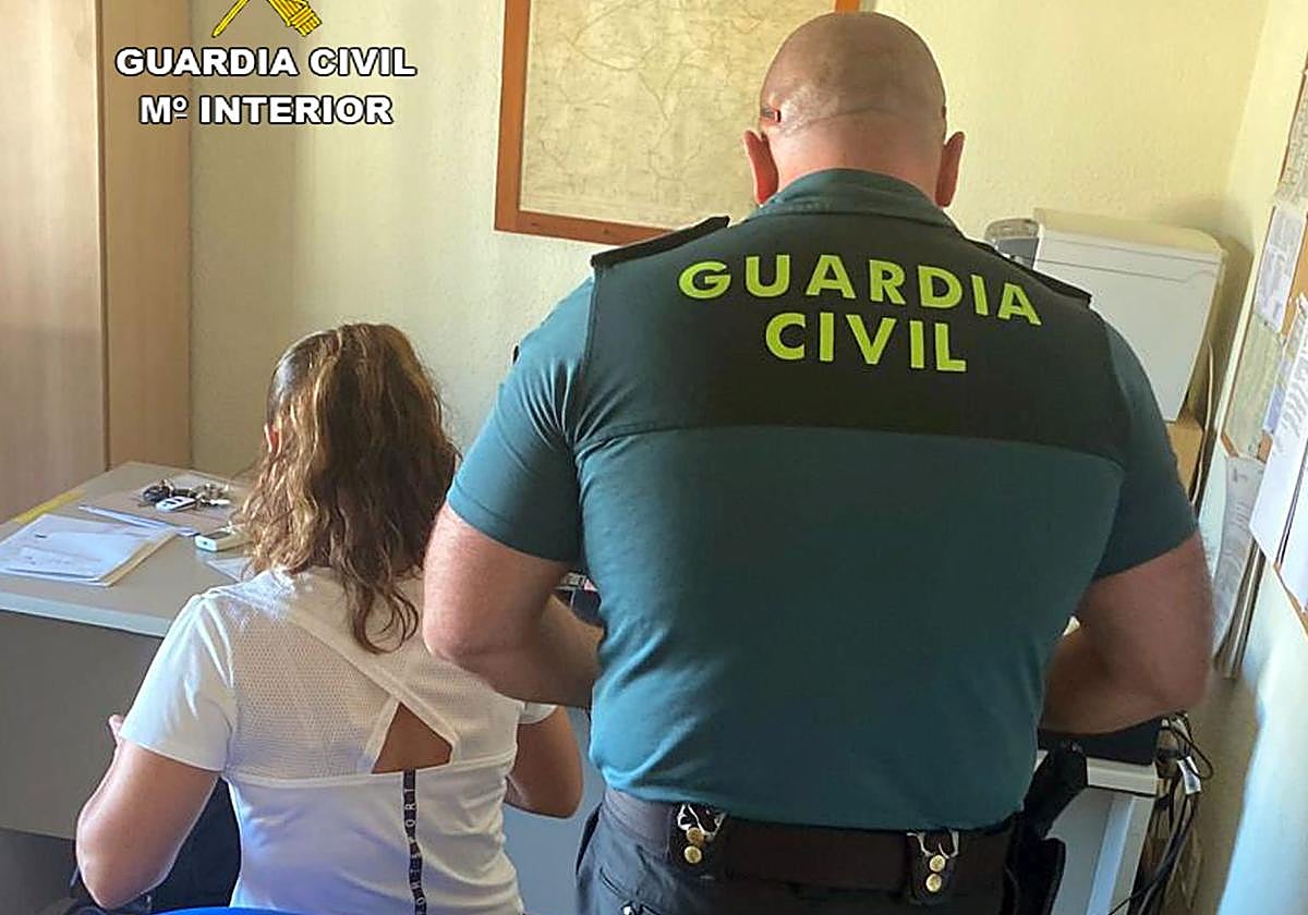 Un agente junto a la arrestada.