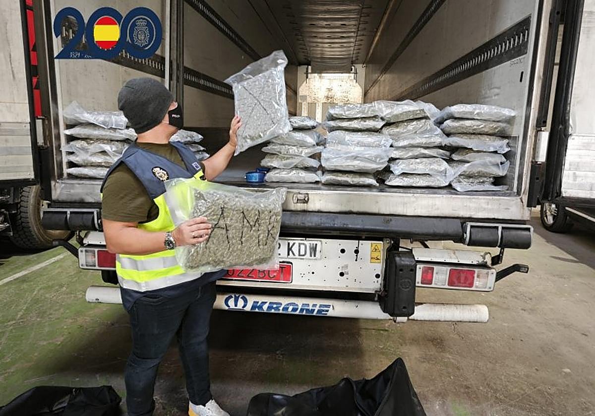 Un agente confisca los 34 kilos de marihuana, tras el registro del camión en una gasolinera.
