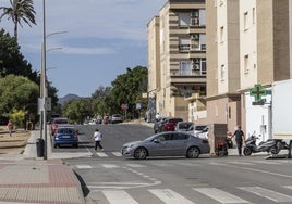 Una mujer y un vehículo pasan por la avenida Nueva Cartagena en el cruce con Sierra de Cazorla, uno de los 'puntos negros' del barrio.