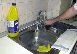 Una persona abre el grifo del fregadero de su cocina.