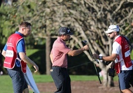 El jugador español Alejandro del Rey devolviendo su palo a su caddie Borja Navarro.