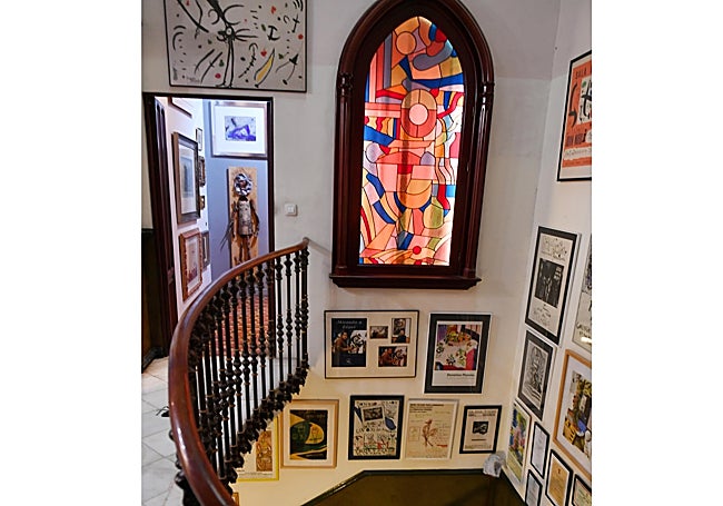 Escalera del palacete con algunos carteles y recuerdos de la galerista.