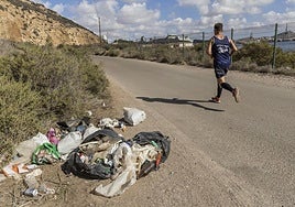 Un corredor pasa ante varias bolsas de basura tiradas en el arcén, esta semana.