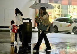 Una mujer se protege de la lluvia ayer en el centro de Murcia.