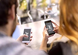 Dos personas utilizan Bizum para realizar un pago.