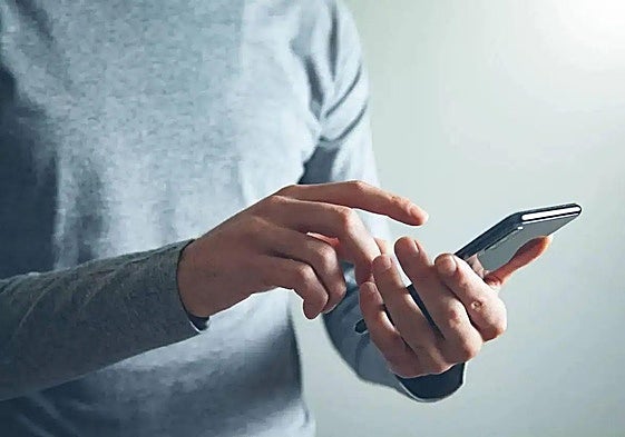 Un hombre utiliza su teléfono móvil en una imagen de archivo.