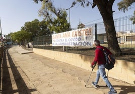 Un vecino de Santa Ana pasa frente a una de las pancartas de «¡Santa Ana existe!», con las que los residentes denuncian la situación de abandono del pueblo.