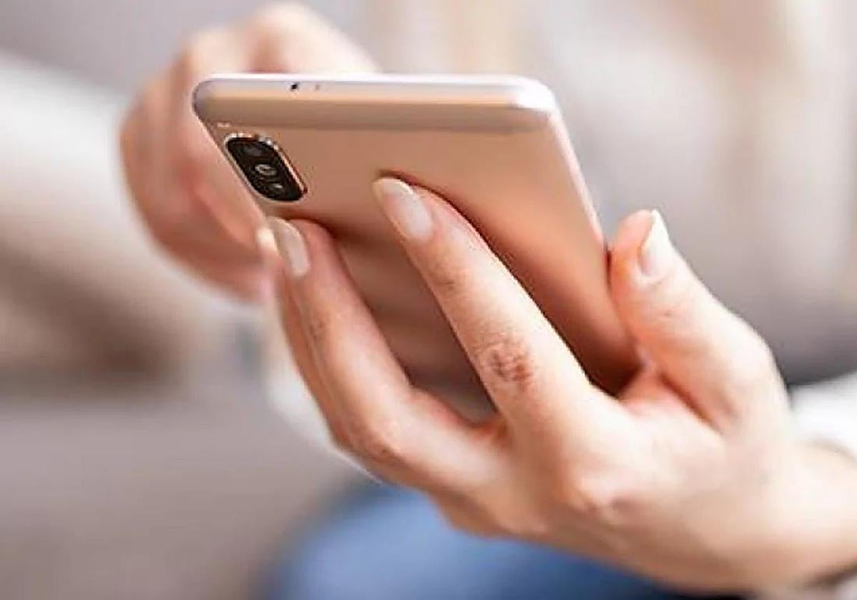 Una mujer utiliza su móvil.