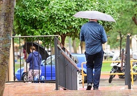 Un hombre se protege de la lluvia con un paraguas en Murcia, en una imagen de archivo.