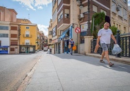 Un hombre pasea por el Puente Viejo con la compra en mano.
