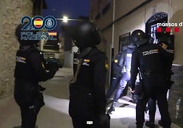 Los agentes tratan de derribar una puerta para proceder al registro de una vivienda.