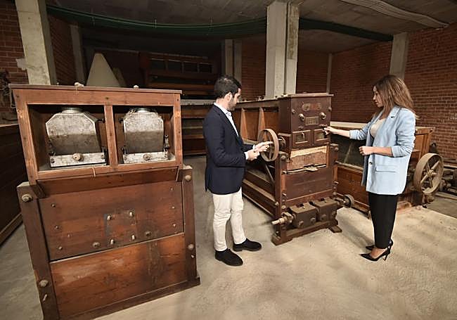 Los concejales Avilés y Pérez comprueban el estado de una de las máquinas de la antigua harinera.