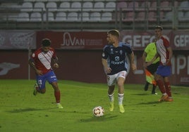 David Vicente, del Real Murcia, conduce la pelota perseguido por Javi Gómez, del Algeciras.