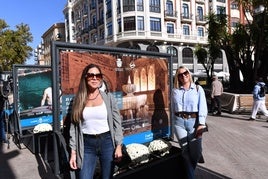 Dos viandantes junto a la muestra fotográfica.