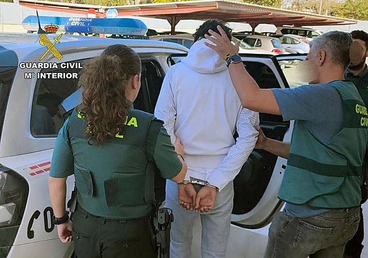 Uno de los detenidos, bajo custodia de la Guardia Civil.